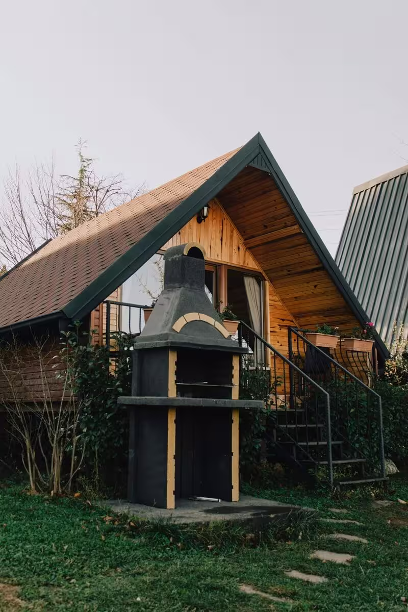Exterior of The Hare shepherd's hut nestled beside hedgerow